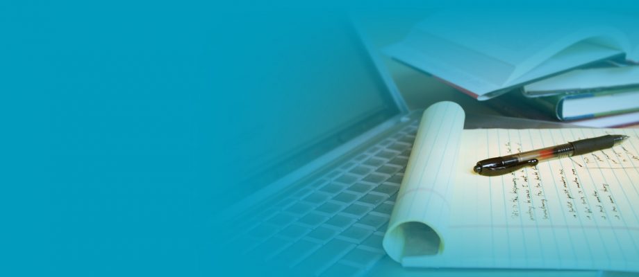 A laptop and pens on a blue background