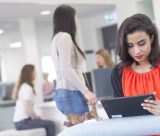 Undergraduate female student using an ipad in University Park Central Student Service Centre, Cherry Tree Lodge