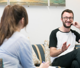 A person in a white and black t shirt being spoken to
